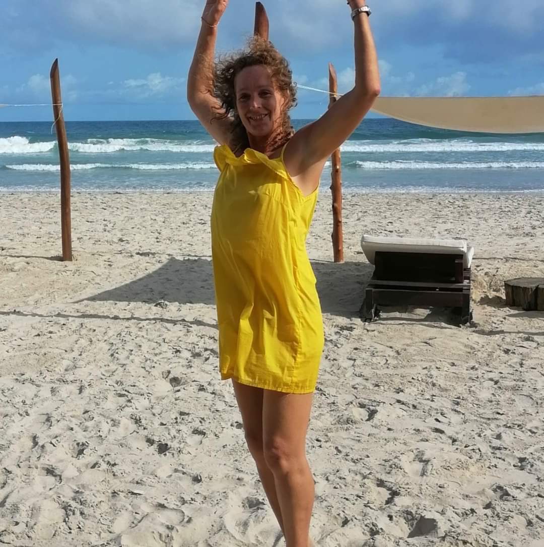Gisele , an Om Reset instructor, is happy on the beach